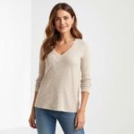 a stylish woman wearing a fall fashion long sleeve v neck tunic top in soft knit fabric,