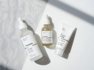 The Ordinary The Daily Set including Squalane Cleanser, Hyaluronic Acid serum, and Natural Moisturizing Factors cream arranged neatly for a minimalist skincare routine.