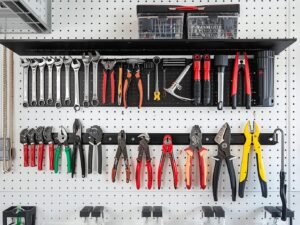 Organized garage wall with TIDYME tool organizer rack holding various tools on a pegboard